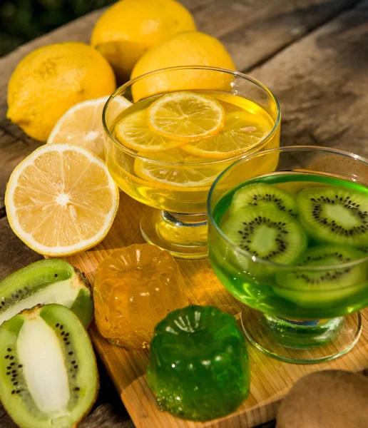 Fresh kiwi jelly and lemon jelly on old wooden background. Tasty healthy vegetarian dessert sugar free.