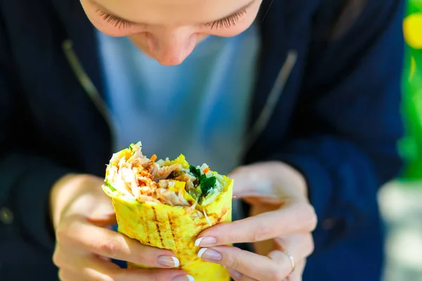 La chica come shawarma en la calle . Fotos de stock libres de derechos