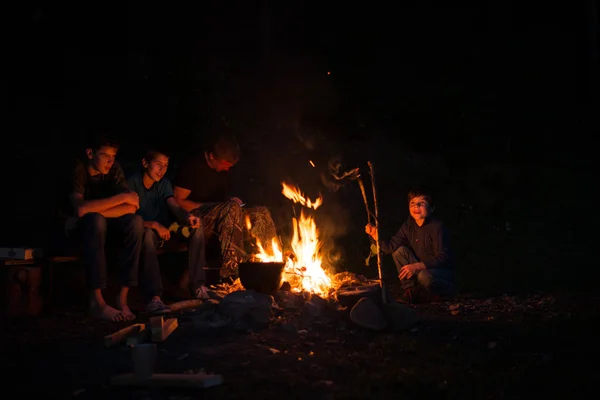 Kinder mit Vater nachts im Wald am Feuer. — Stockfoto