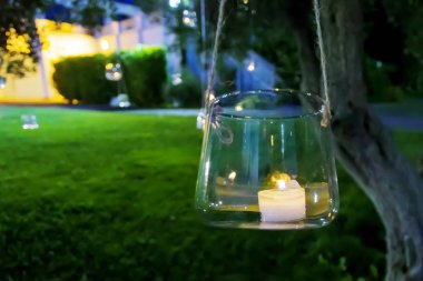 candle in a glass hanging from a tree clipart