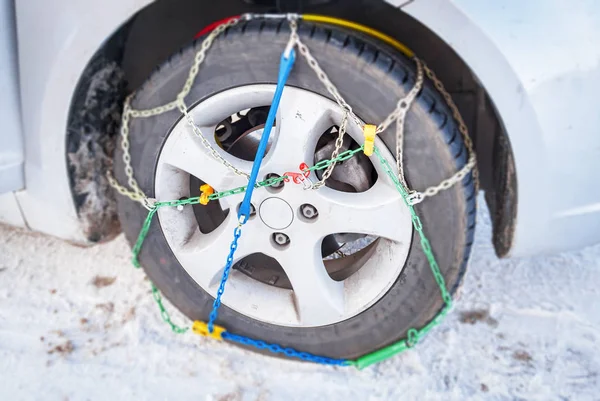 Wiel van een auto met gemonteerde winter kettingen — Stockfoto