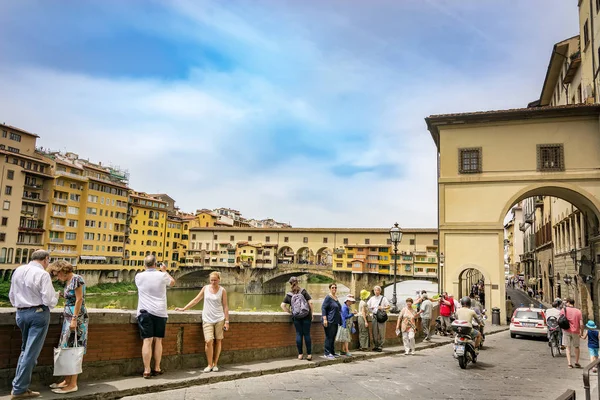 Turisti che camminano e scattano foto lungo il famoso Lungarno nei pressi di Ponte Vecchio a Firenze — Foto Stock