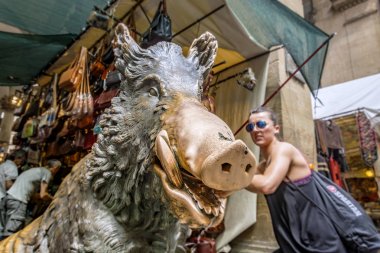  Mercato del Porcellino (domuz yavrusu Pazar) bir turist ile bir domuzu ve bazı deri çanta satıcıları bulanık arka planda ünlü bronz heykeli görünümünü kapat