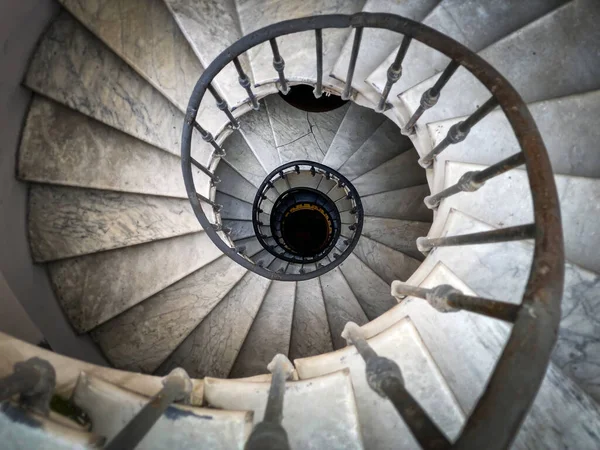 Ancient spiral staircase with decorated wrought iron handrails and marble steps inside an old palace in Rome. — Stock Photo, Image