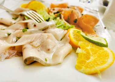 Çiğ deniz ürünleri bir restoran masasında servis edilir.