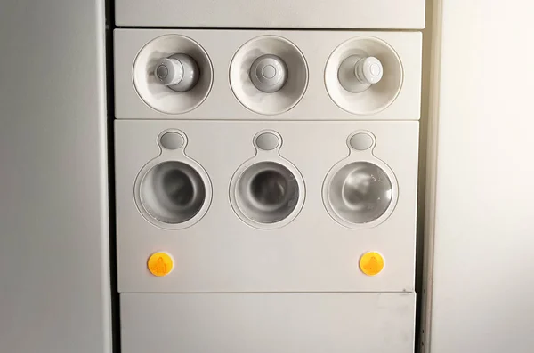 Luces y acondicionadores de aire regulables en los mandos de los asientos de una aeronave comercial en un avión —  Fotos de Stock
