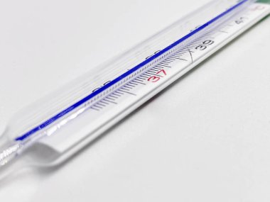 Beyaz arka planda izole edilmiş cıva bir termometre. Tıbbi ölçüm aleti. Virüs ve grip