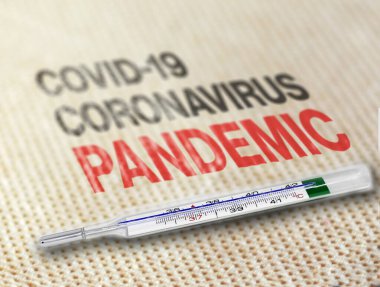 Yumuşak bir yüzeyde dinlenen bir termometre Covid-19 Coronavirus salgınını gösteriyor. Dünya çapında virüs salgını