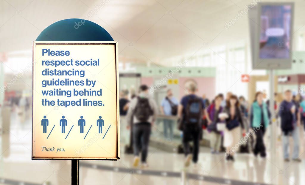 a sign inside an airport warns of the need to maintain the minimum safety distance between people to avoid contagion during the COVID-19 Coronavirus pandemic. Airport security measures.
