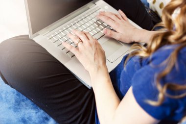 Laptop klavyesinde yazı yazan beyaz bir kadın. Evden çalışıyorum. Akıllı çalışma konsepti