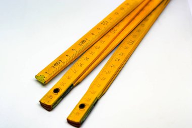 Pirinç uçlu sarı ahşap taksimetre beyaz arka planda izole edilmiş. Boyutu tam olarak 2 metre uzamış. İnşaat sektöründe kullanılan ölçü aleti