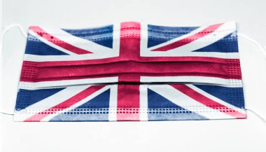 İngiltere bayrağı basılmış cerrahi maske. Salgın covid-19 ve virüsün yayılmasını önleyici önlemler