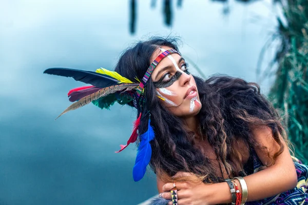 Native American girl in national clothes looking towards lake — Stock Photo, Image