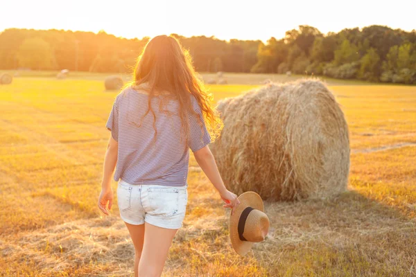 Mulher bonita com cabelos longos encaracolados no campo de restolho de verão — Fotografia de Stock