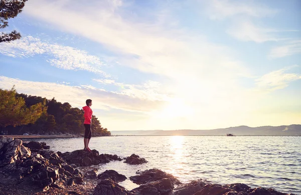 Mujer joven descansando y relajándose en la playa después de correr — Foto de Stock