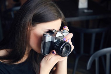 Genç kız fotoğrafçı ile eski analog kamera Cafe