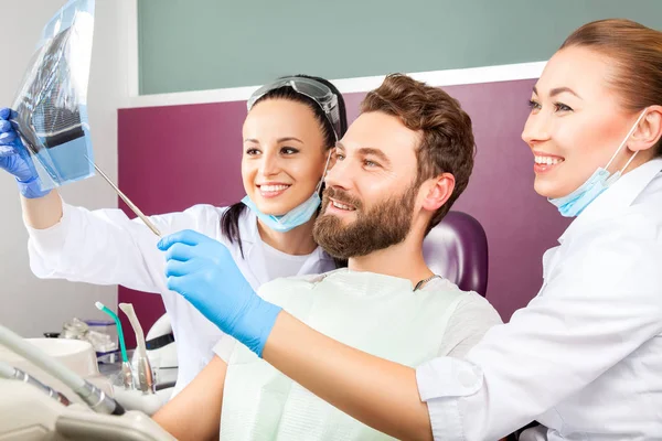 Dentista mostra um paciente raio-X dos dentes . — Fotografia de Stock