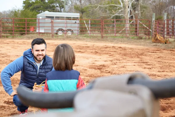 Far lärande son kasta lasso till bull simulator i ranch — Stockfoto