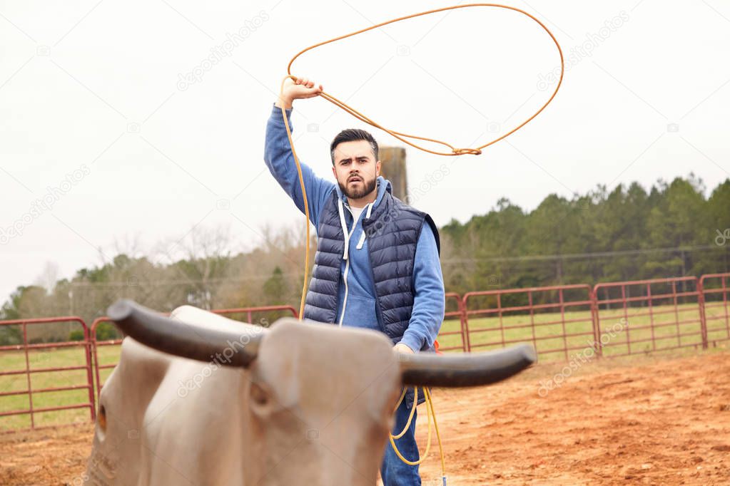 Man training making loope and throwing lasso to bull simulator