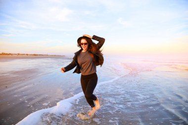 Eğleniyor ve okyanus kıyısında plaj üzerinde çalışan kadın