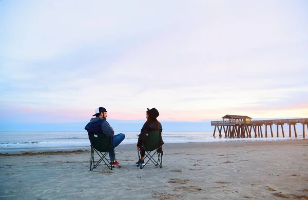 Güzel gün batımı kumsalda şezlong içinde oturan Çift — Stok fotoğraf