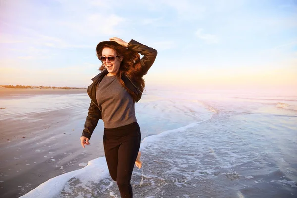 女人开心和运行在海洋海岸的海滩上 免版税图库图片
