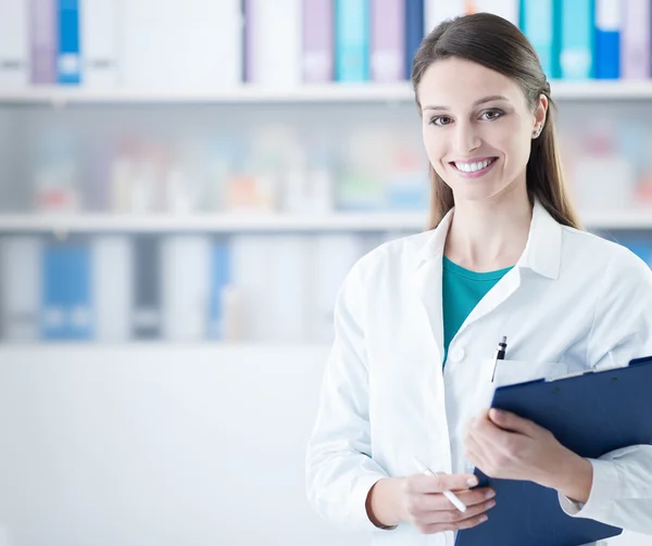 Usmívající se žena doktor drží schránky — Stock fotografie