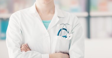 Doktor kollarını kavuşturmuş poz veriyor.