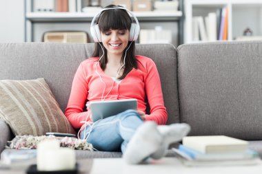 Kadın kulaklıklarla tablet kullanma