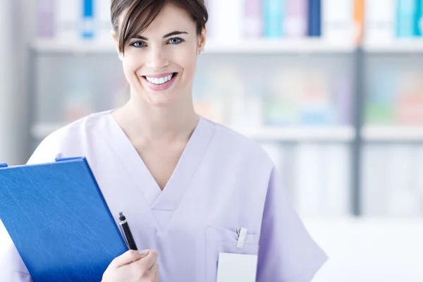 Médico sorridente segurando relatórios médicos — Fotografia de Stock