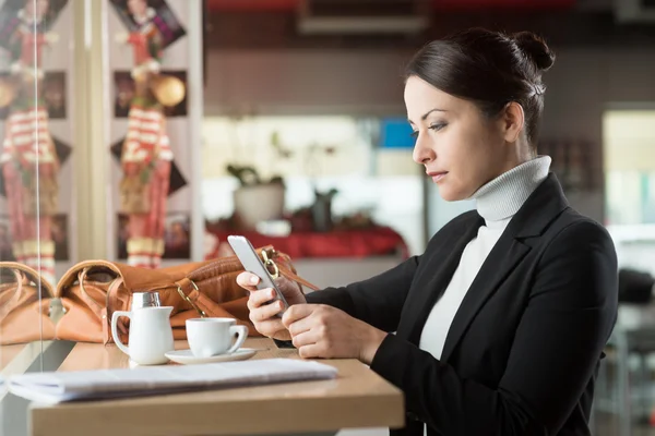 Frau an der Bar beim SMS-Schreiben mit ihrem Handy — Stockfoto