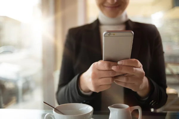 Empresaria de mensajes de texto con su teléfono inteligente —  Fotos de Stock