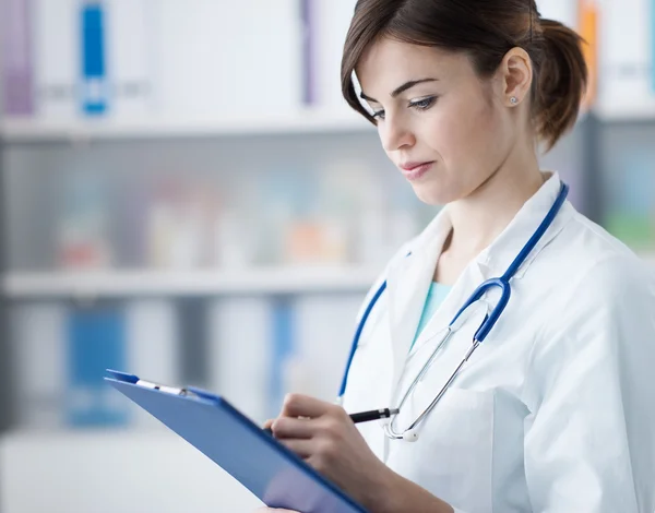 Doctor writing medical reports — Stock Photo, Image