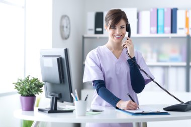 Klinikte gülümseyen resepsiyon görevlisi