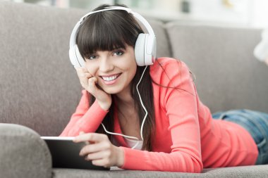 Kadın kulaklıklarla tablet kullanma