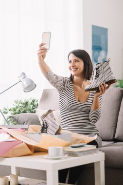 Woman taking a selfie with her new purchases clipart