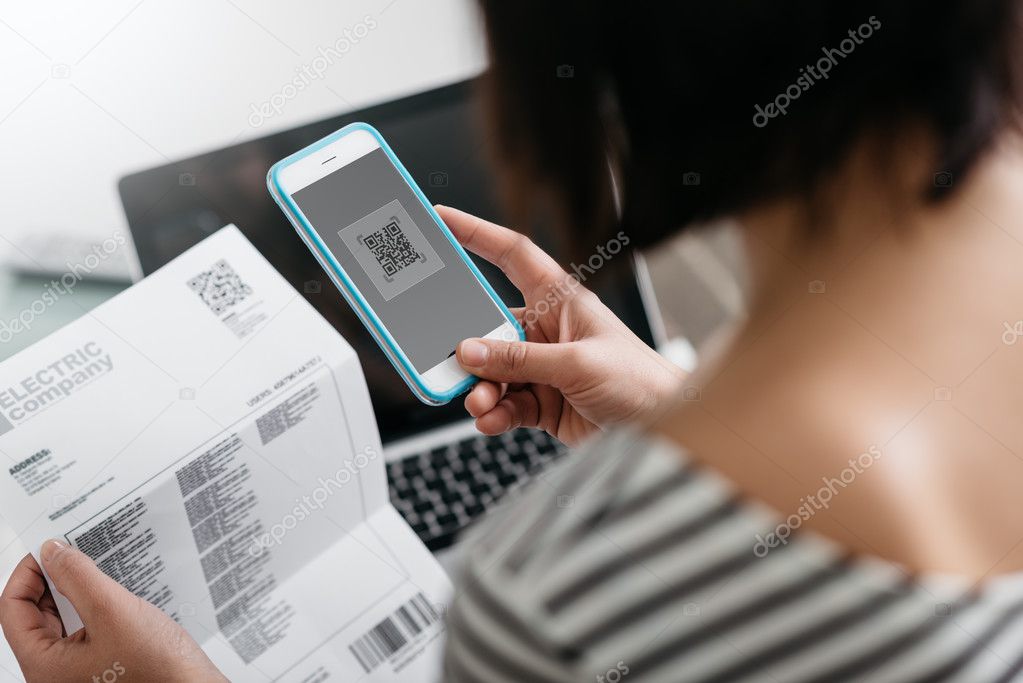 Woman paying bills with her smartphone