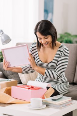Woman unboxing a parcel clipart