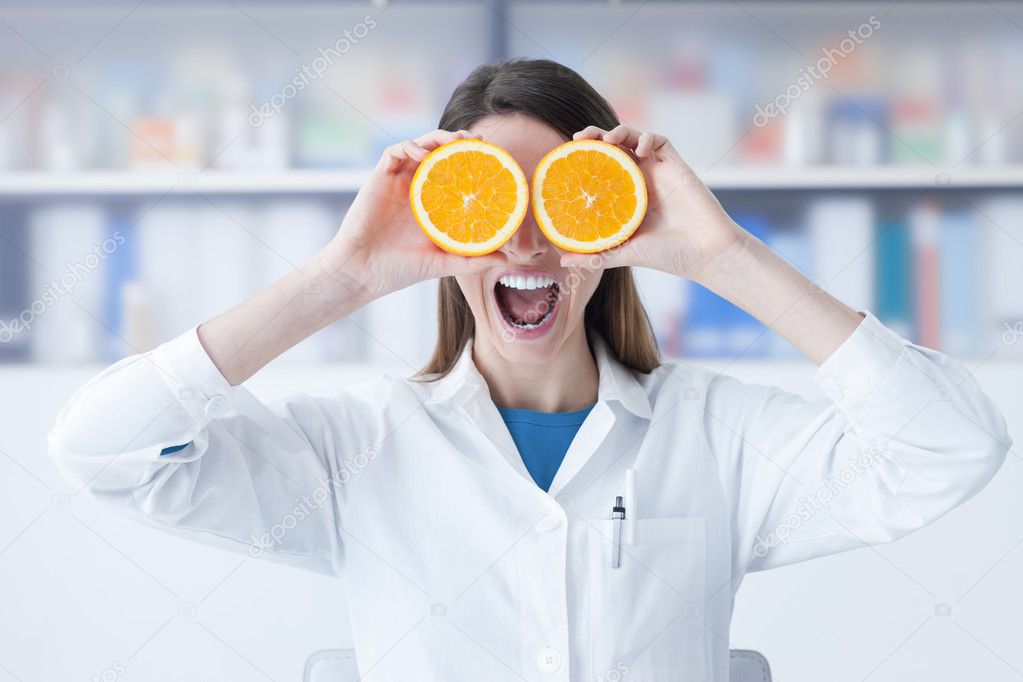 Nutritionist holding oranges over her eyes