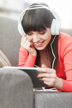 Kadın kulaklıklarla tablet kullanma