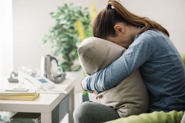 Smutna kobieta przytulanie poduszkę — Zdjęcie stockowe