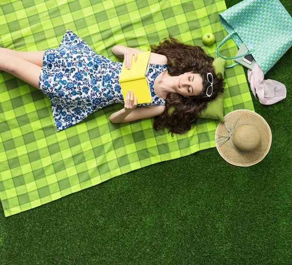 Menina bonito relaxar ao ar livre na grama e ler um livro romance — Fotografia de Stock