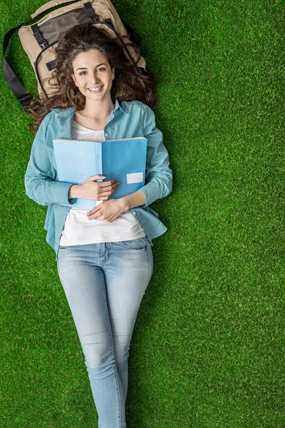 Estudante relaxante na grama — Fotografia de Stock