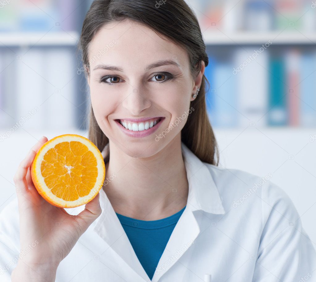 Nutritionist holding a sliced orange