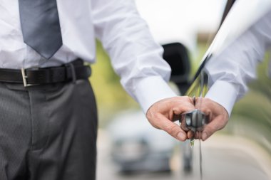 Bir arabanın kapısını açarak iş adamı