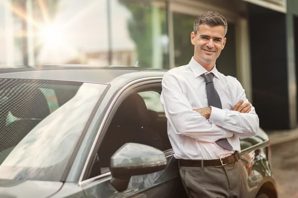 Geschäftsmann posiert mit seinem Auto — Stockfoto