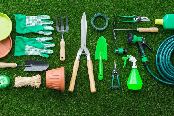 Conjunto de herramientas de jardinería en la hierba exuberante en el jardín, la puesta plana — Foto de Stock