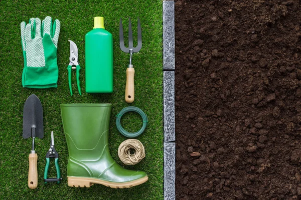 Herramientas y utensilios de jardinería en la hierba y el suelo fértil humus —  Fotos de Stock