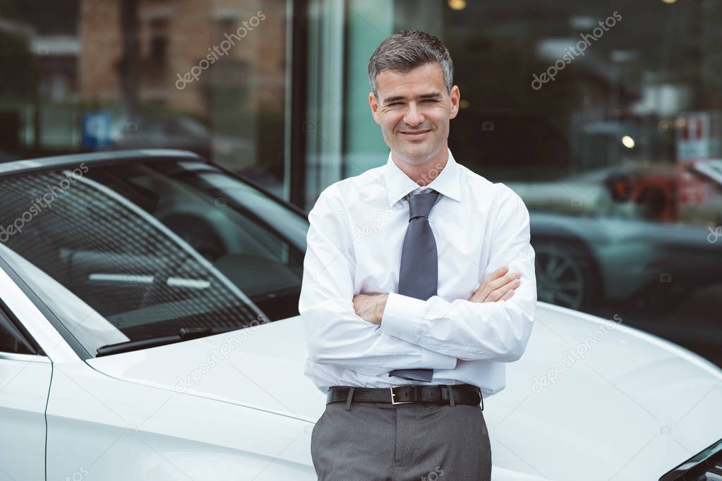 Businessman posing with his new car