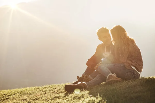 Молода пара сидить на траві — стокове фото